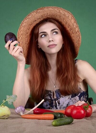 Junges Mädchen hält statt Süßigkeiten eine Aubergine in der Hand. Die Kosten für das Abnehmen mit Hypnose haben sich gelohnt.