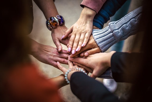 Team Hände im Kreis. Coaching oder Supervision: Wo liegt der Unterschied?